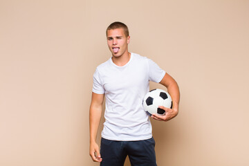 young blonde man with cheerful, carefree, rebellious attitude, joking and sticking tongue out,...