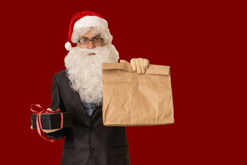 a delivery man in a santa hat delivering a gift with a bow - isolated