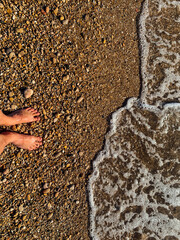 a wave comes in, as I stand and wait. copy space. top down view.