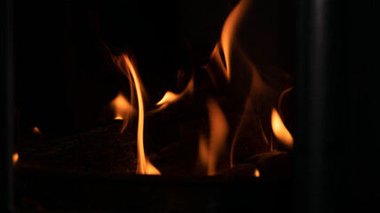 fire in the fireplace close-up on a dark, background image
