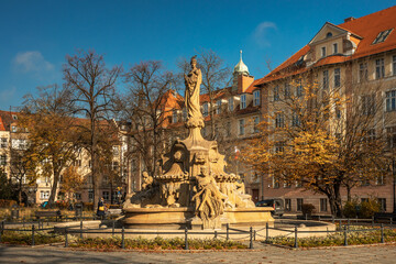 Plac Daszynskiego z zabytkową fontanną w Opolu w jesiennej scenerii w świetle popołudniowego światła.