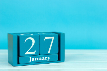 wooden calendar with the date of December 27 on a blue wooden background, International Day of Remembrance for the Victims of the Holocaust