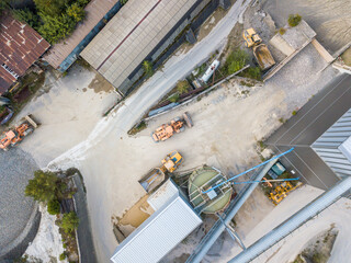 Aerial view of industry plant in sand and gravel mine. Heavy machinery in pit: Dumper Truck and wheel loader.