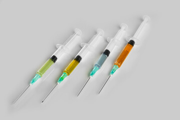 close-up of four syringes with colored vaccine