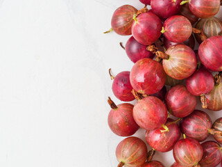 Fresh gooseberry on white wooden background.