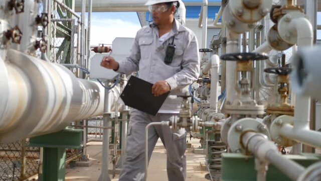 Field workers are inspecting the equipment, measuring and control equipment of the supply station for the industrial plant. Petroleum oil and refinery plant