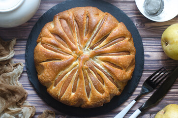Pie with pears and powdered sugar on a board