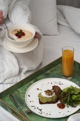 Woman reading book while having breakfast in bed.