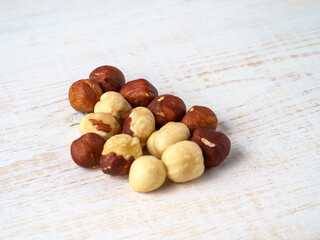 Hazelnuts on white wooden background.