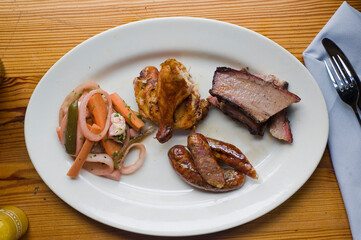 Barbecue catering platter with variety of meats. Traditional Texas BBQ: Beef brisket, beef ribs, pork ribs, sausage links, black pepper roasted chicken, and turkey served with homemade sauce.