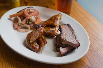 Barbecue catering platter with variety of meats. Traditional Texas BBQ: Beef brisket, beef ribs, pork ribs, sausage links, black pepper roasted chicken, and turkey served with homemade sauce.