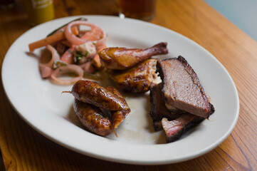 Barbecue catering platter with variety of meats. Traditional Texas BBQ: Beef brisket, beef ribs, pork ribs, sausage links, black pepper roasted chicken, and turkey served with homemade sauce.