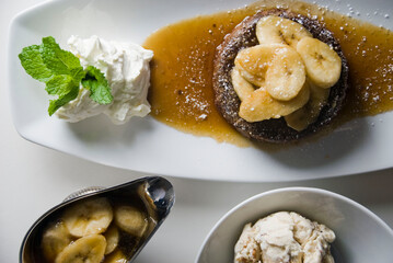 Bananas foster Dessert. Classic Creole or Cajun dessert favorite. Bananas sautéed in butter and caramelized sugar and served with cookies, whipped cream, cake, ice creams and chocolate syrup.