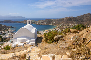 View of Ios Island with a small white chapel on top of a mountain in the city center of Chora. Ios...