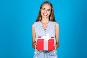 Young girl holding gift box on blue background