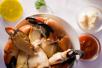 Stone crab claws. Colossal Crab claws served with lemons, spicy rémoulade sauce on top of a mixed green salad. Classic American restaurant or steakhouse appetizer or entree.
