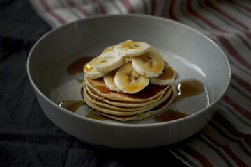 Homemade pancakes with banana and maple syrup