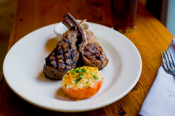 Lamb Chops. Grass-fed lamb, grilled to a medium rare and served with a garlic herb butter sauce and paired with roasted potatoes and Brussels sprouts. Classic American steakhouse favorite. 