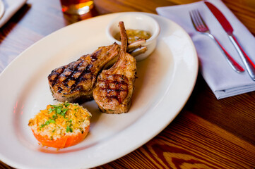 Lamb Chops. Grass-fed lamb, grilled to a medium rare and served with a garlic herb butter sauce and paired with roasted potatoes and Brussels sprouts. Classic American steakhouse favorite. 