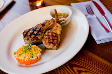 Lamb Chops. Grass-fed lamb, grilled to a medium rare and served with a garlic herb butter sauce and paired with roasted potatoes and Brussels sprouts. Classic American steakhouse favorite. 