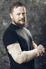 Matured man with bandaged hand studio portrait.