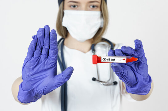 The doctor holds in his hands a test tube with blood tests for the virus - CK-MB with the other hand he makes a gesture - stop.