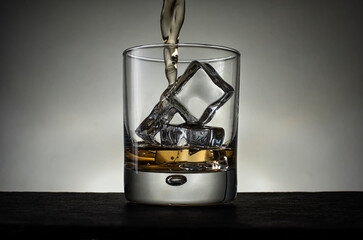 Whisky Pouring into a Glass  with Ice