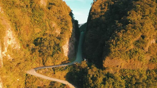 Amazing road inside a tropical rainforest mountain crack at sunrise aerial view, Serra Do Corvo Branco, Gr&atilde;o Par&aacute;, Santa Catarina, Brazil