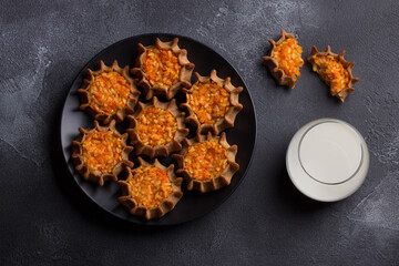 Traditional karelian, finnish, russian mini pies "kalitki" or "koliadki" stuffed with carrots, rice and milk on black textured background, flat lay © olepeshkina