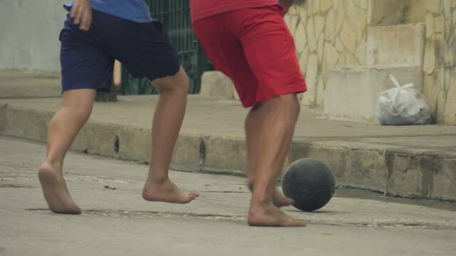 Children Training Playing Football Barefoot In Ghetto, Cuba. Footbal game around the world concept. The Republic of Cuba, urban scene. Football and soccer in Cuba
