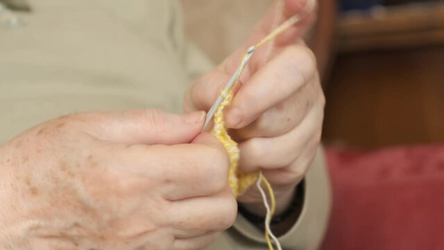 Knitting. Senior adult hands knitting wool close-up. Arts and craft. Homemade hobby activity.