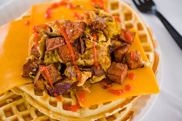 Chicken and waffles. Classic American Diner Style Breakfast or Brunch menu item favorite. Crispy homemade fried chicken on top of home buttermilk waffles topped with butter and maple syrup. 