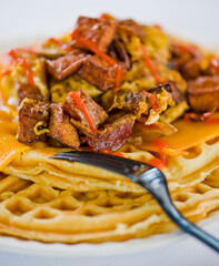 Chicken and waffles. Classic American Diner Style Breakfast or Brunch menu item favorite. Crispy homemade fried chicken on top of home buttermilk waffles topped with butter and maple syrup. 