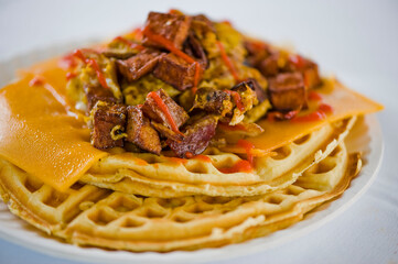 Chicken and waffles. Classic American Diner Style Breakfast or Brunch menu item favorite. Crispy homemade fried chicken on top of home buttermilk waffles topped with butter and maple syrup. 