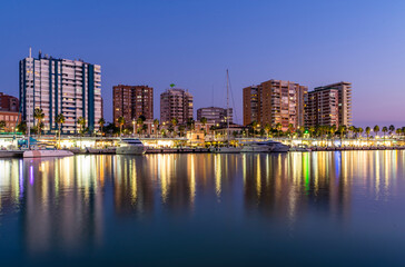 Fototapeta na wymiar Overview of City and Reflection of Lights on Malaga Port Water