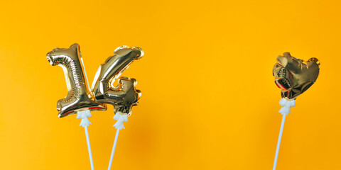 Golden 14 balloons and heart isolated on yellow background. Helium balloons, gold foil numbers....