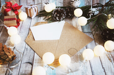 Vintage envelope with a blank sheet of white paper on the background of New Year's decor. View from above. Christmas or winter planning concept.