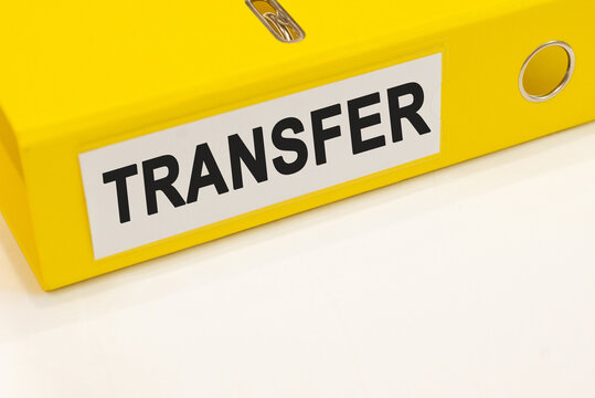 The word transfer on a white background with a yellow folder. Business concept