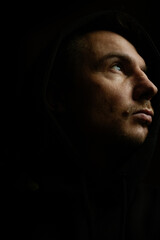 Man on a dark background with a neutral expression. Film grain and noise effect.