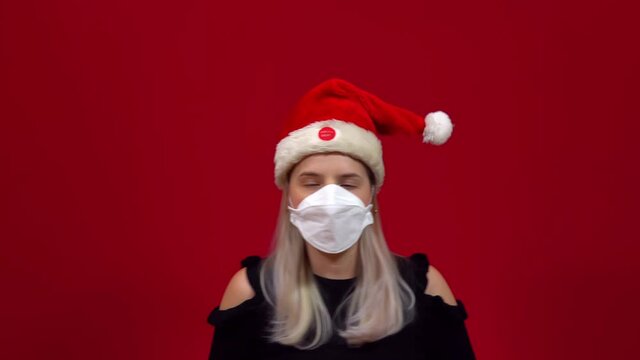 Woman in medical mask singing and dancing along with a dancing christmas live hat on her head