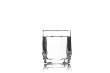 Glass tumbler with edges filled with water isolated on white background with reflection