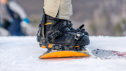 Close up view of legs in boots on snowboard outside