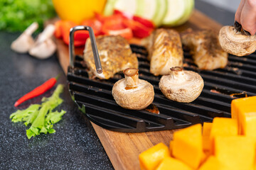 Grill rack with ready-made mushrooms and fish.