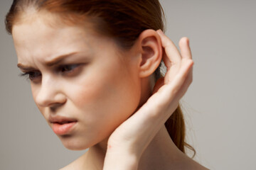 Fototapeta premium disgruntled woman holding her ear health problems close-up