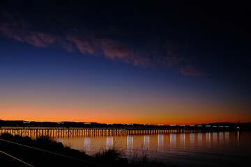 Twinkling lights on pier and spectacular sunrise.  White Rock, BC
