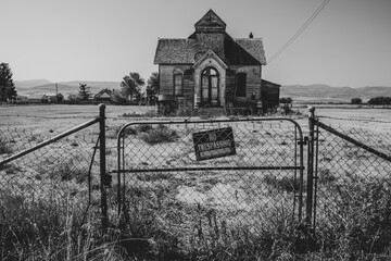 Old, abandoned LDS mormon church in Ovid, Idaho. No trespassing sign and fence