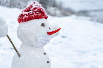 Profile snowman in a protective mask with chili instead of a nose welcomes Christmas with open...