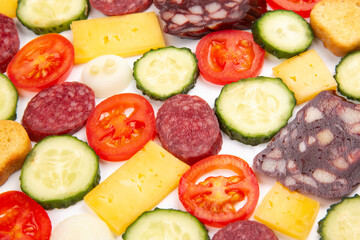 sliced ​​pieces of sausage, salami, cheese, cucumber and tomato. fast food. ingredients for pizza. calories and diet