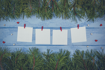 Christmas or New Year mock up: pine branches and white stickers with red clothespins on the blue boards