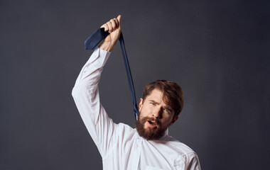 man holding tie in hand and choking suicide gray background model cropped view